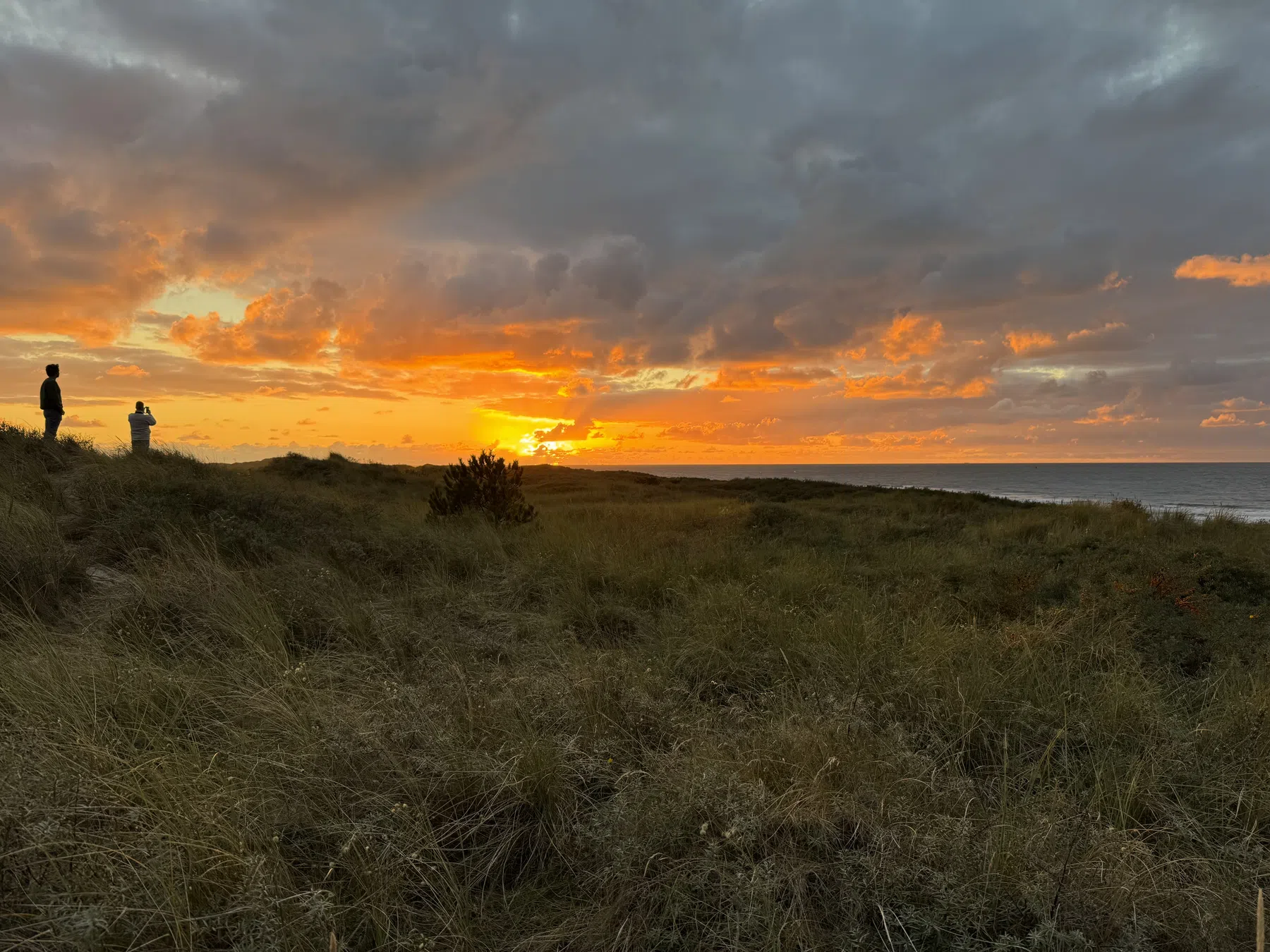 De zon gaat onder in de duinen.