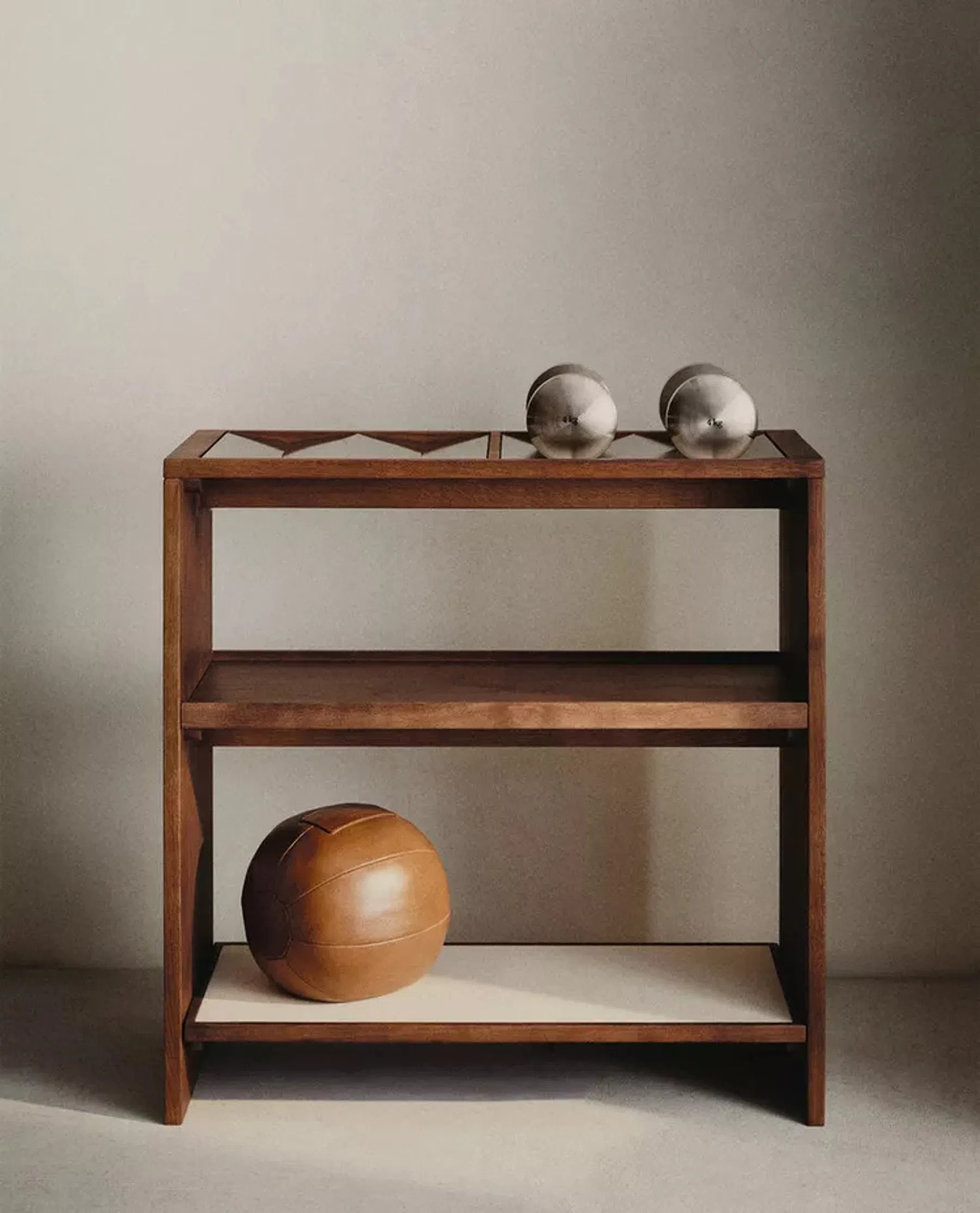 Zara Home Gym Collection: houten kastje met bovenin twee stalen dumbbells en onderin een leren bal