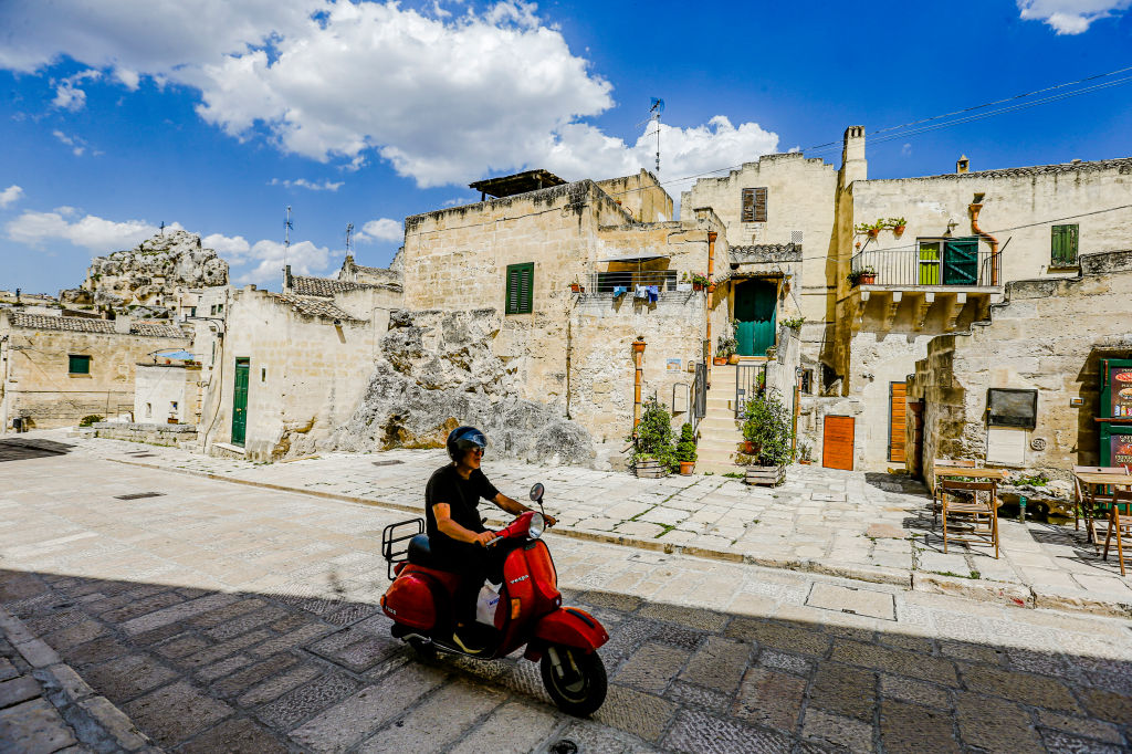Man op vespa in Sassi di Matera, Italië