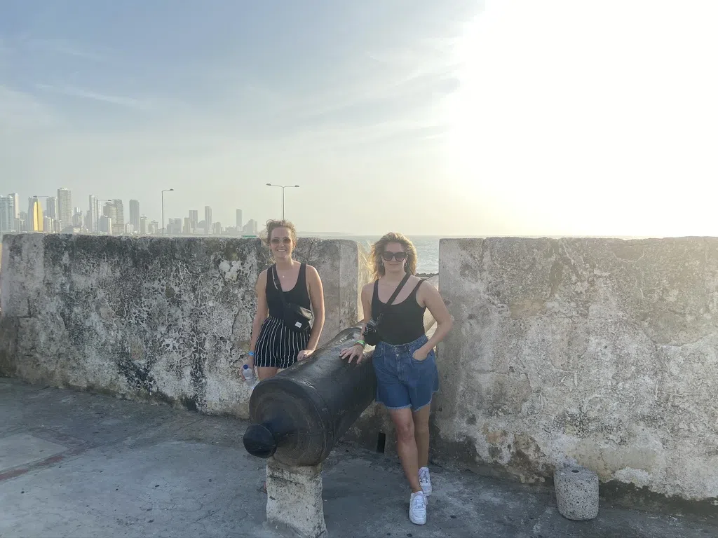 Twee vrouwen poseren bij een kanon. Eén van hen draagt een bijna onzichtbare beenprothese.