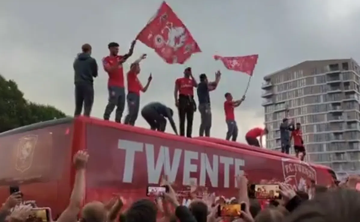Twente-spelers vieren onder toeziend oog van honderden fans feest op dak van bus